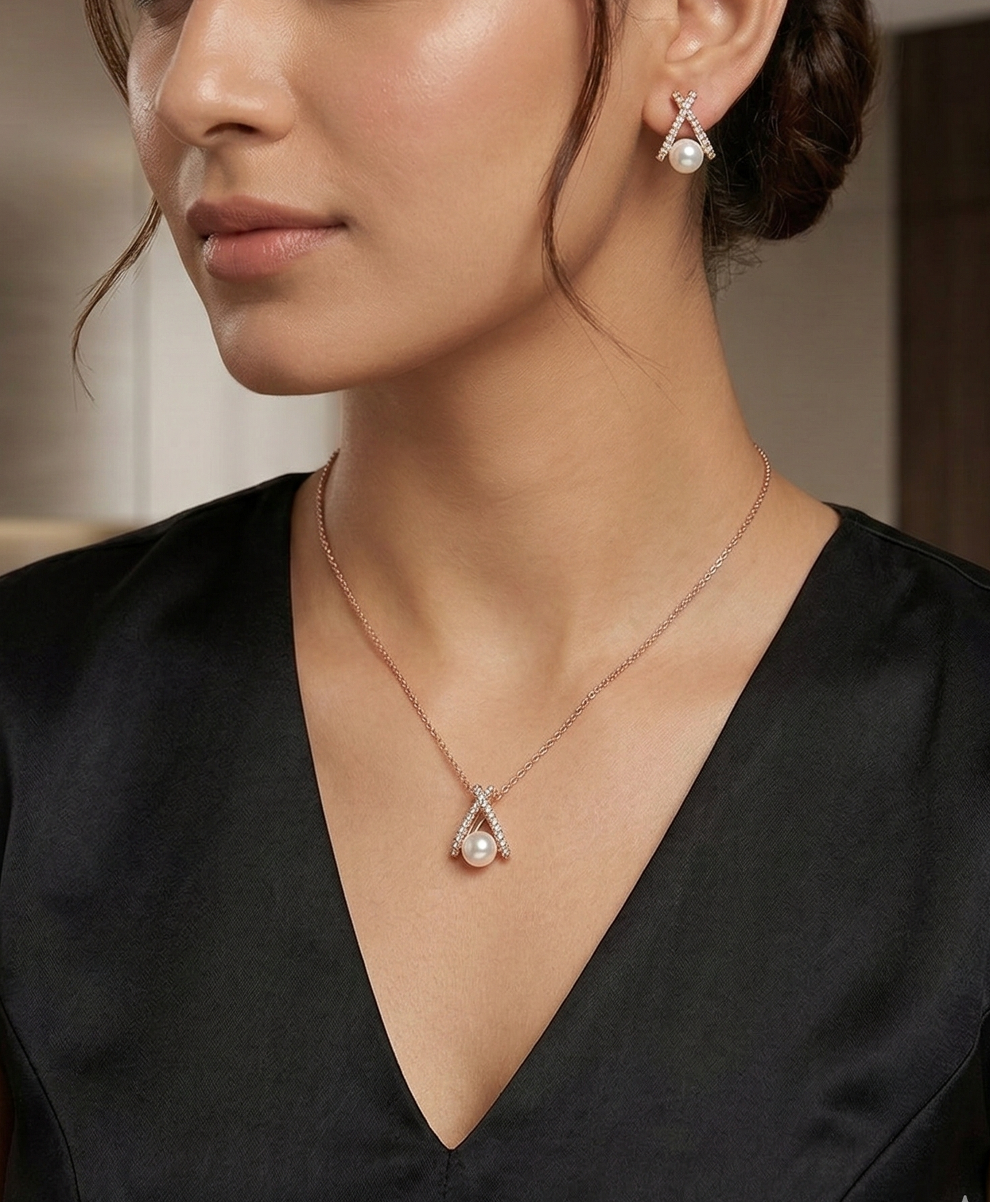 Woman wearing a black top with a necklace and earrings indoors.