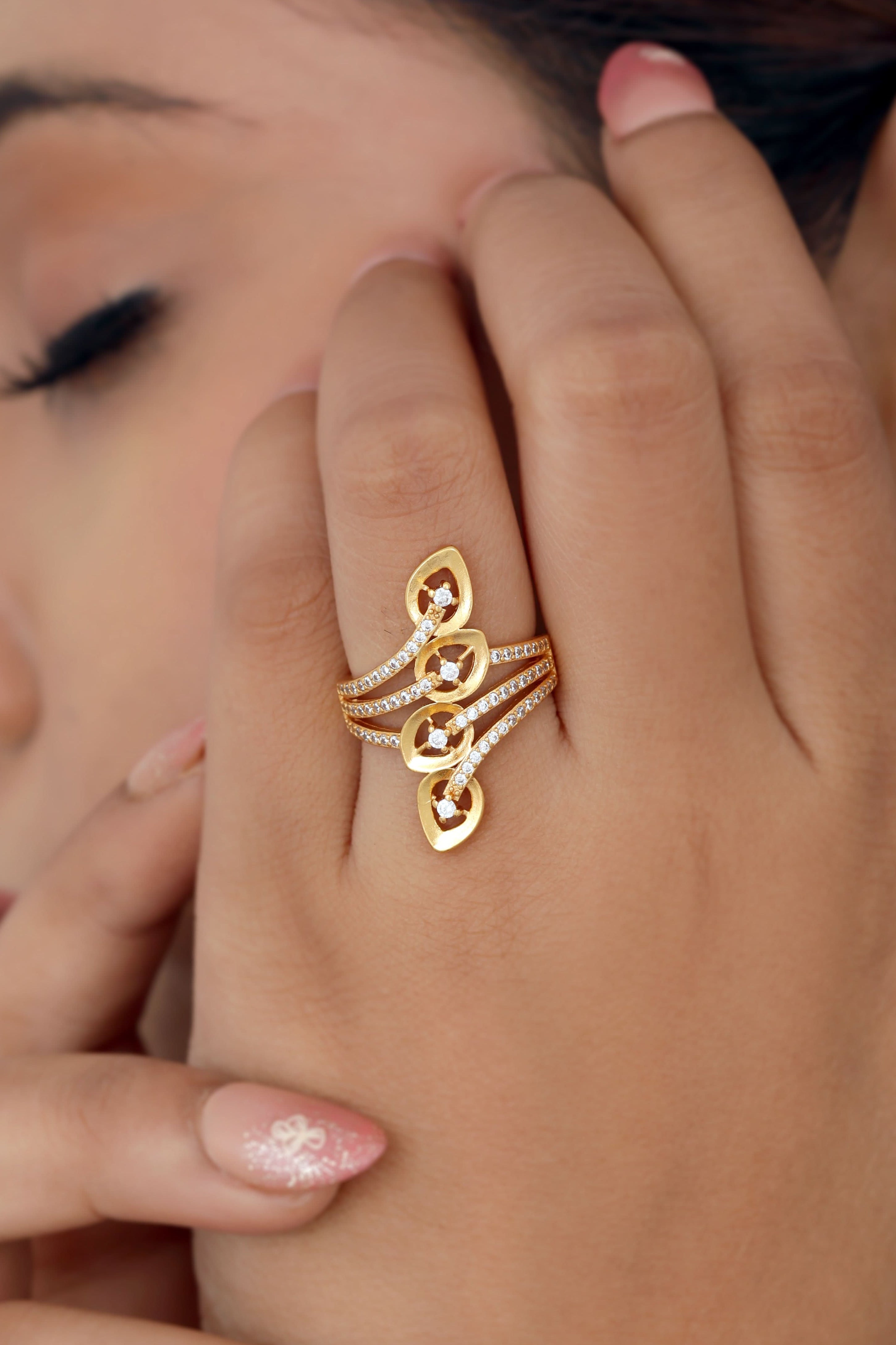 Close-up of a woman's hand wearing a gold ring with a white background