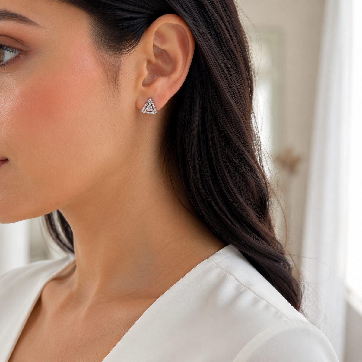 Silver triangular stud earring styled for daytime