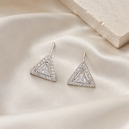Silver triangular stud earrings on ivory silk