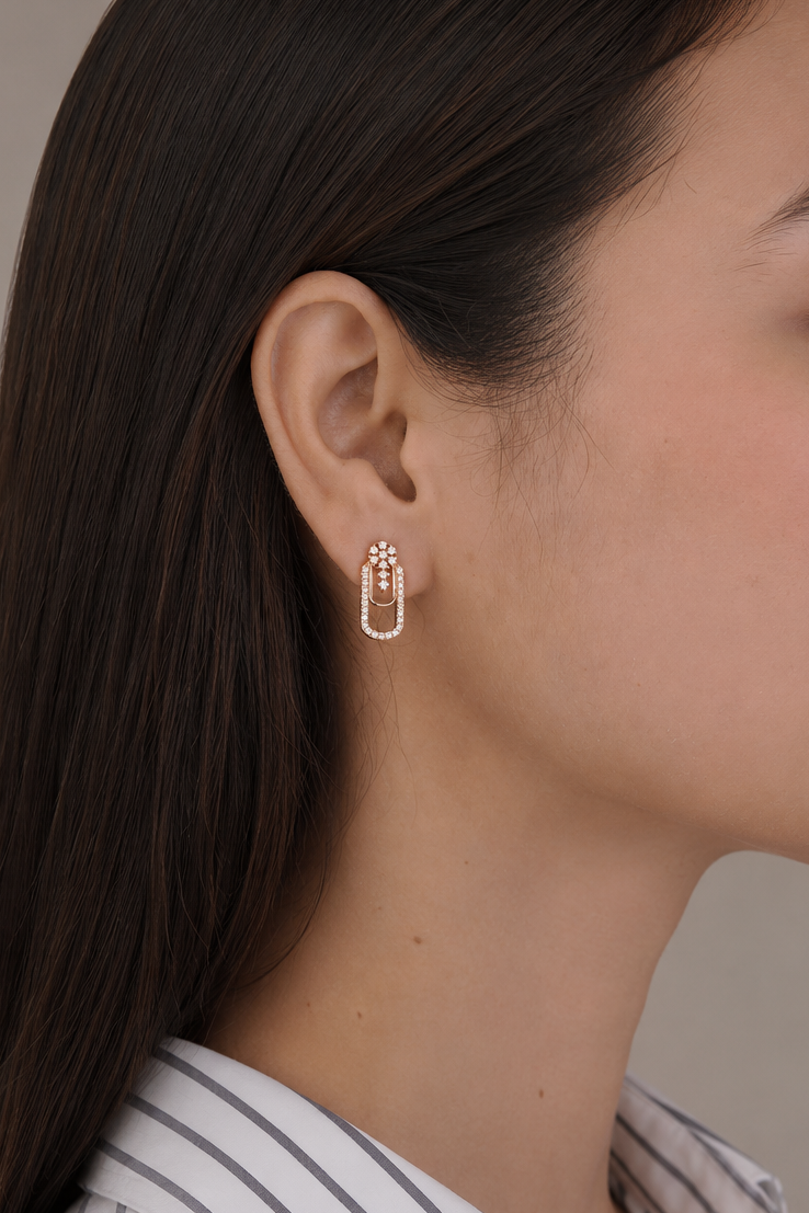 Woman wearing a gold hoop earring against a neutral background