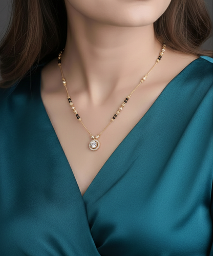 Woman wearing a gold necklace with a blue top