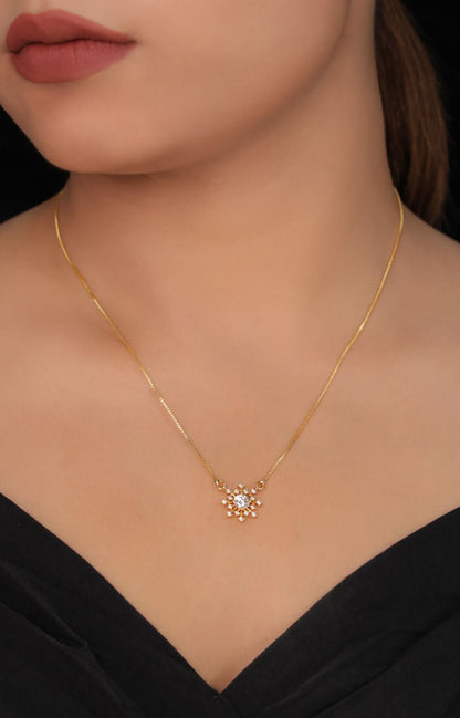 Gold necklace with a star-shaped pendant worn by a model against a black background
