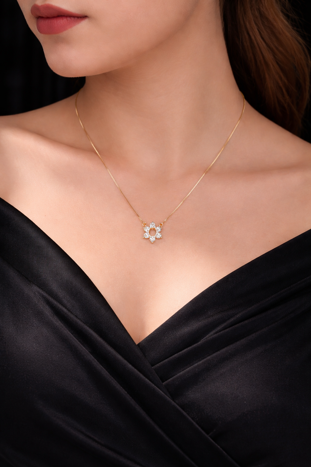 Necklace with a floral pendant worn by a model against a dark background
