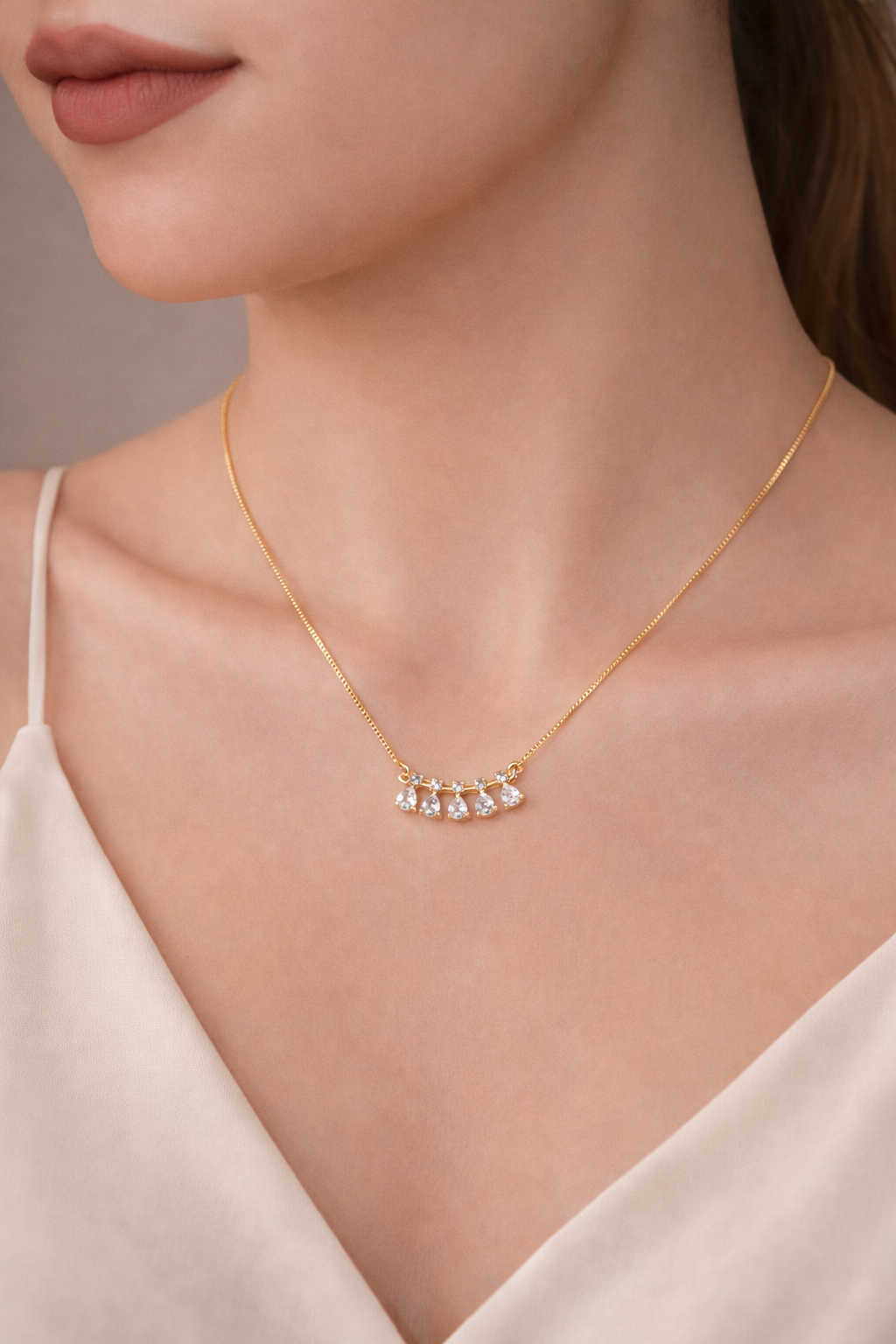 Gold necklace with small diamonds on a model wearing a white top