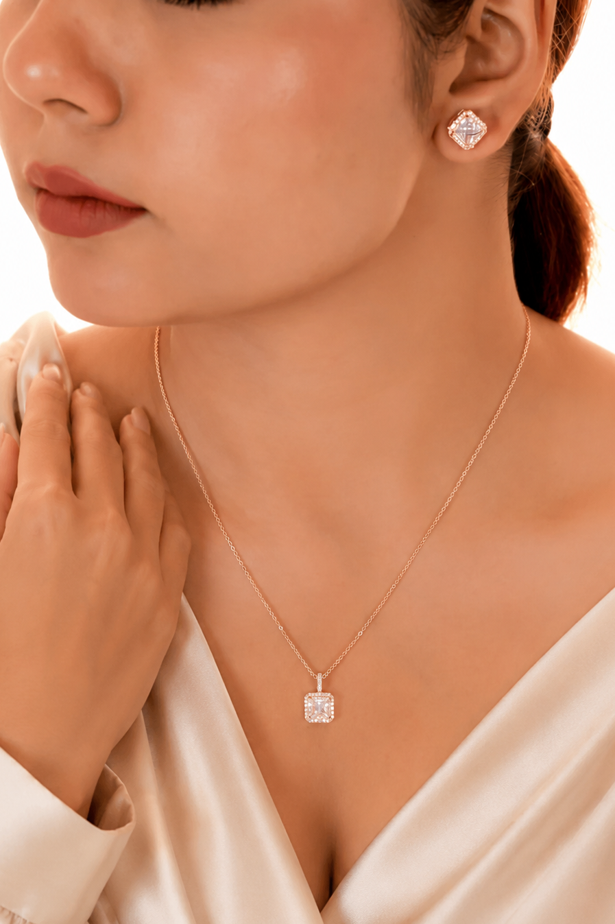 Woman wearing a diamond necklace and earrings on a beige background