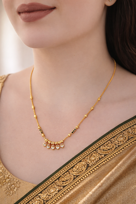 Gold necklace worn by a person with a blurred background