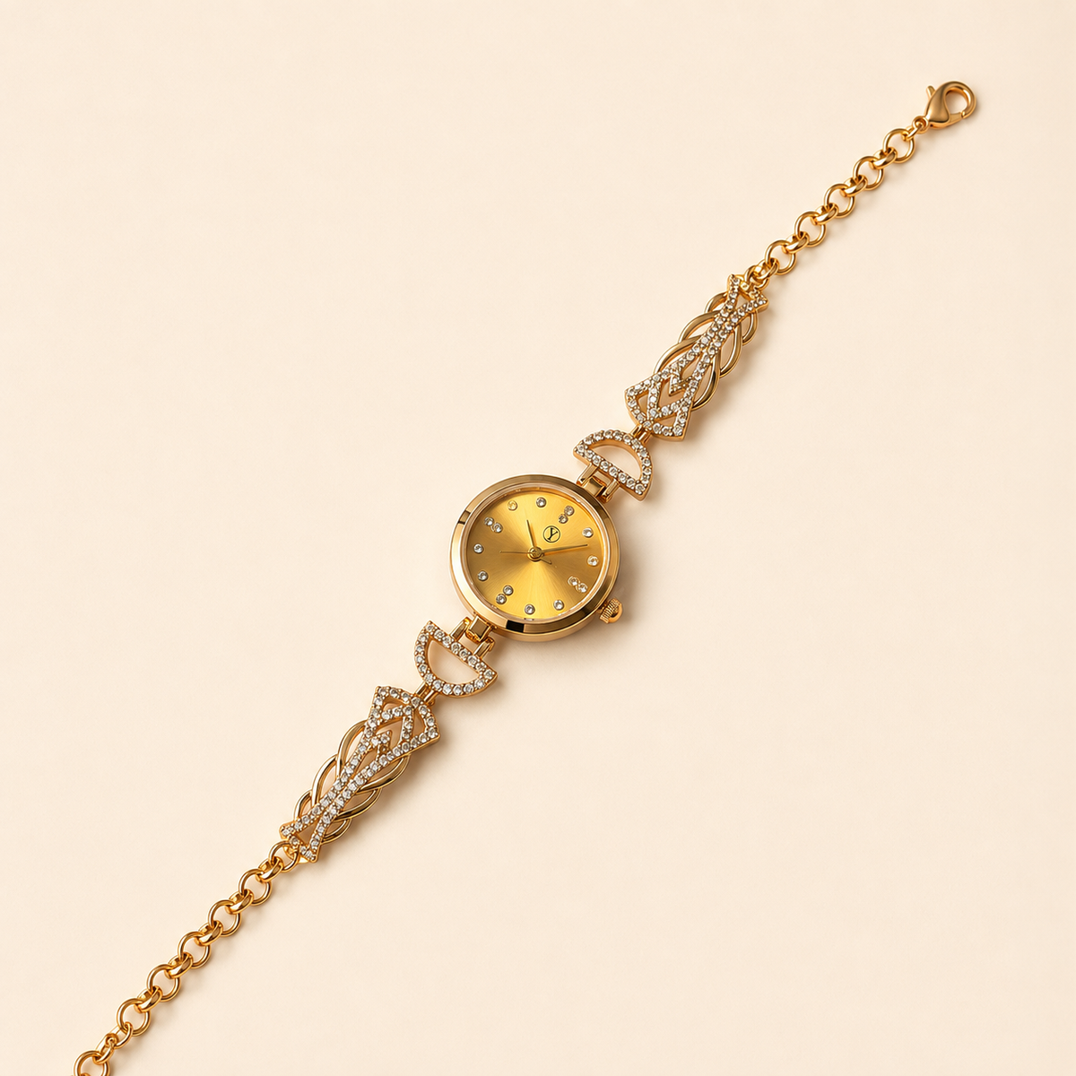 A gold-tone watch with a delicate chain bracelet, featuring crystal-embellished decorative links and a round dial with gold-tone hour markers, shown on a light beige background.