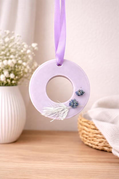 Decorative purple wreath with flowers hanging on a light background