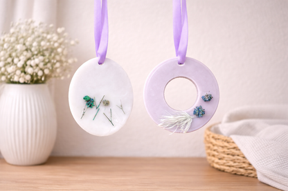 Two decorative circular ornaments with floral elements hanging on a white background.