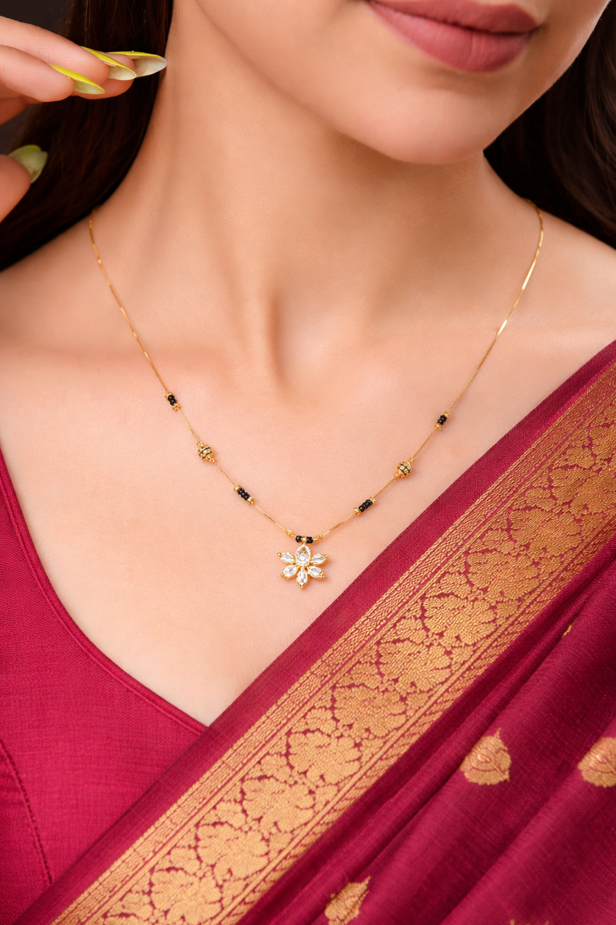 Woman wearing a gold necklace with a maroon saree