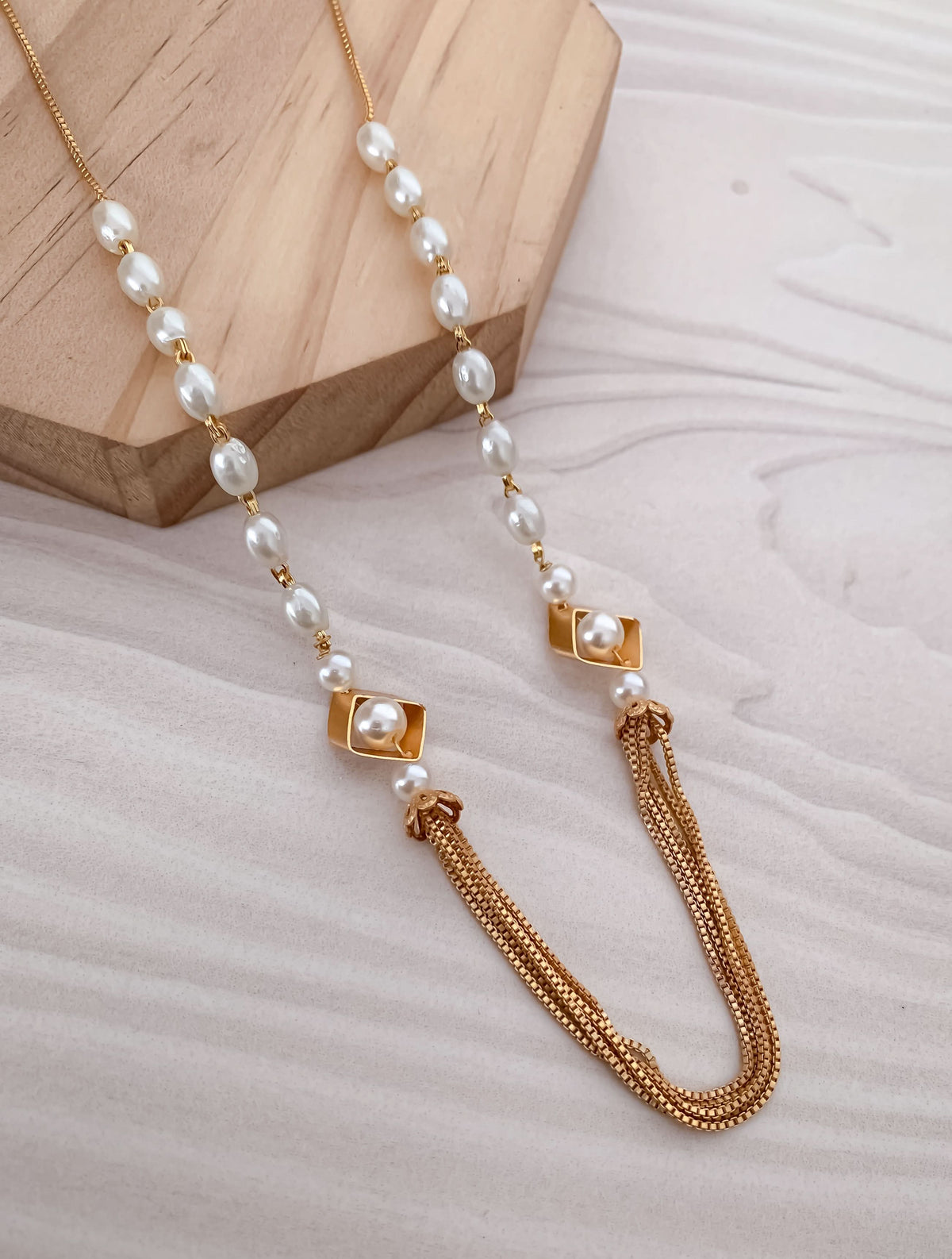 Pearl necklace with gold accents on a textured surface