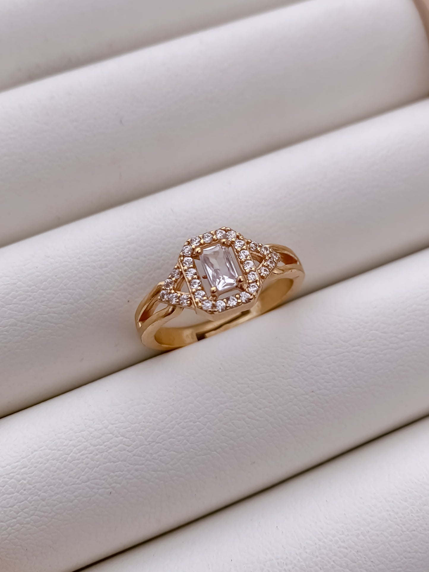 Rose gold ring with a diamond on a white surface