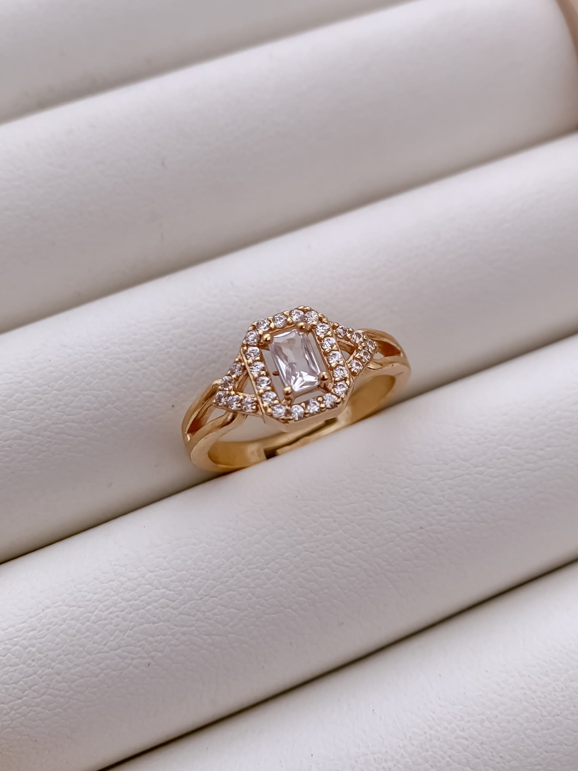 Rose gold ring with a diamond on a white surface