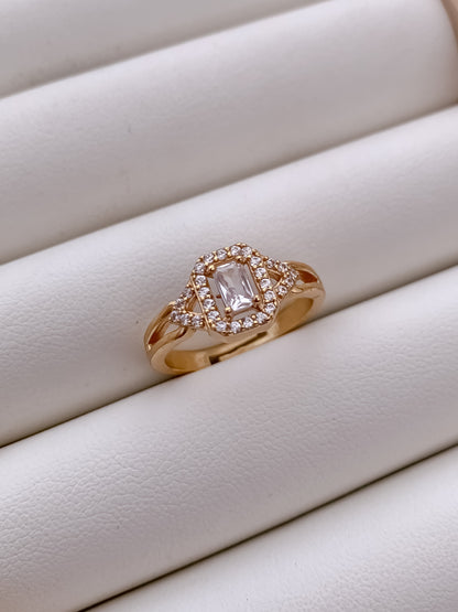 Rose gold ring with a diamond on a white surface