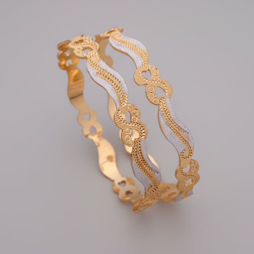 Gold and silver bracelet on a pink background with flowers