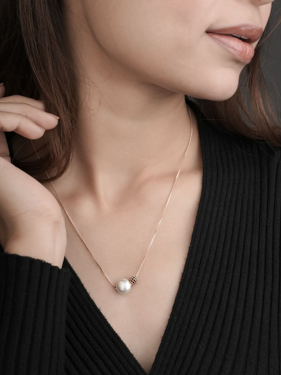 Woman wearing a pearl necklace against a neutral background