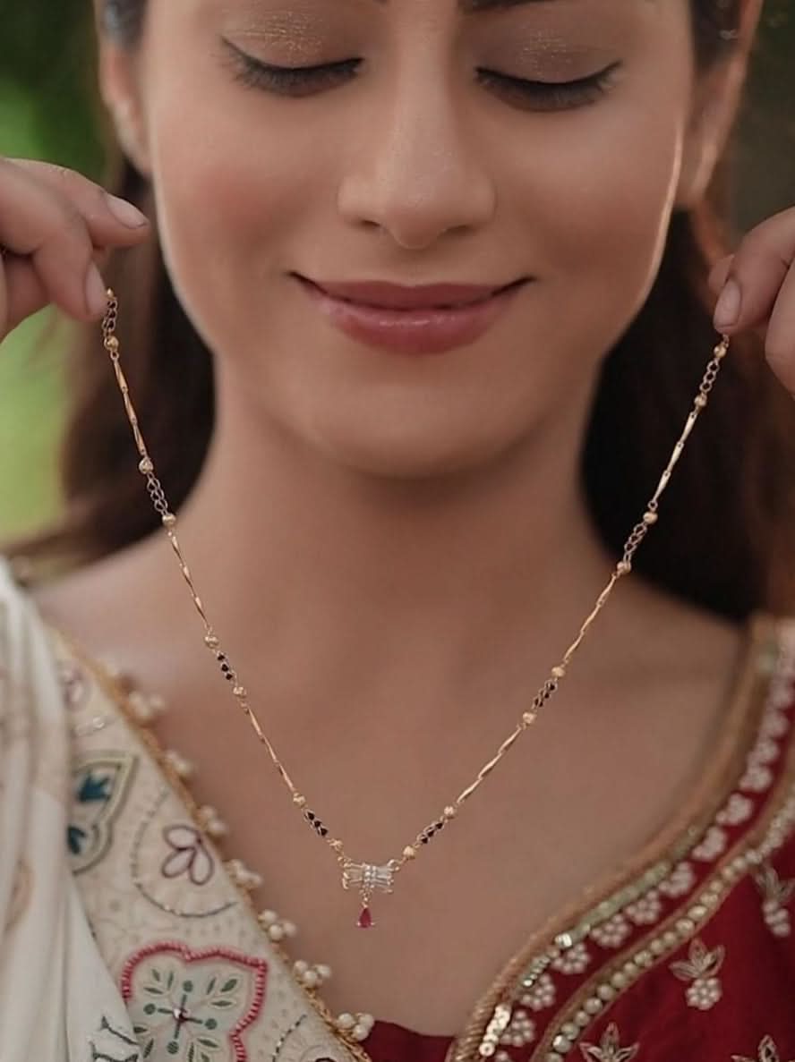 Woman wearing a traditional embroidered outfit with a Mangalsutras 