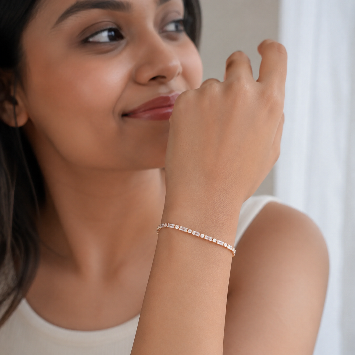 Woman wearing the gold baguette and round stone tennis bracelet in natural daylight