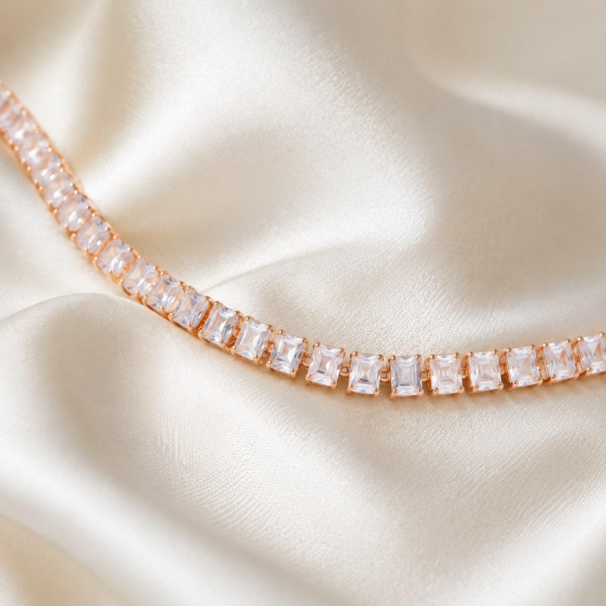 Rose gold baguette tennis bracelet on ivory silk
