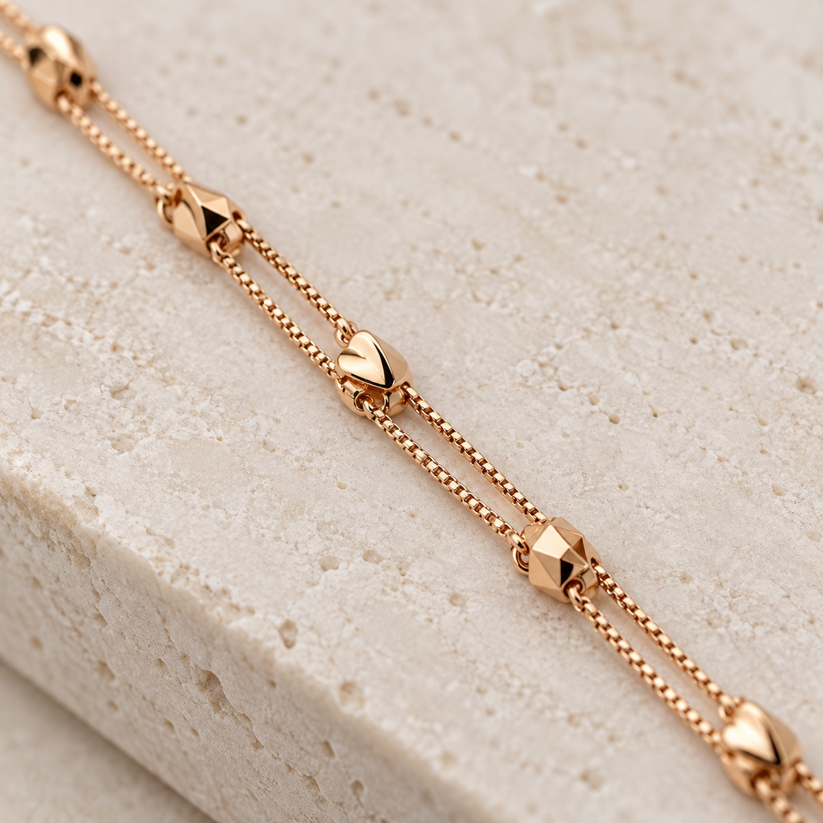 Close-up of the faceted geometric charms and double chain bracelet detail