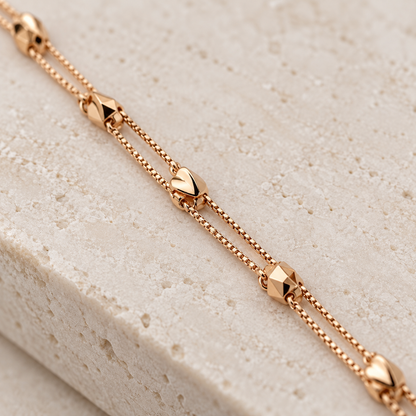 Close-up of the faceted geometric charms and double chain bracelet detail