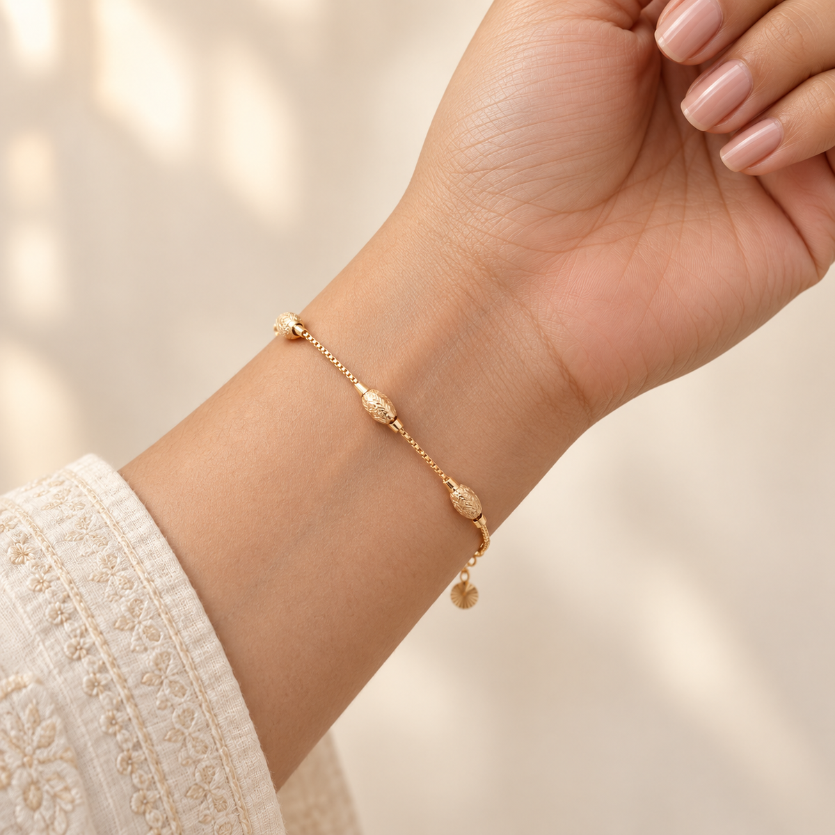 Textured oval bead gold-tone bracelet worn on wrist