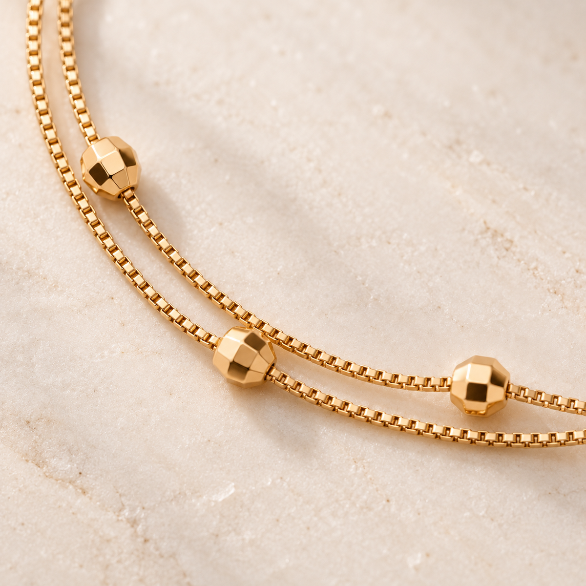 Close-up of faceted beads and double gold-tone chains
