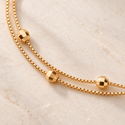 Close-up of faceted beads and double gold-tone chains