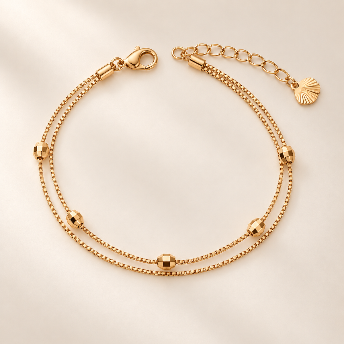 Faceted bead double-layer gold-tone bracelet on warm ivory