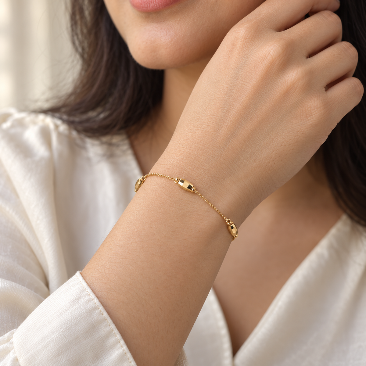 Minimal gold-tone bead chain bracelet worn on wrist